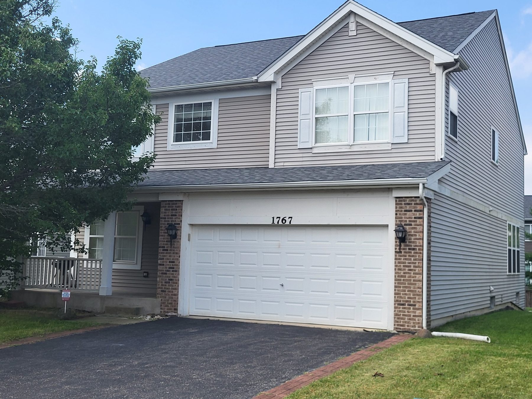 Front exterior of 1767 Seaton Ct: two-story home with vinyl siding, brick accents, covered front porch and a two-car attached garage.