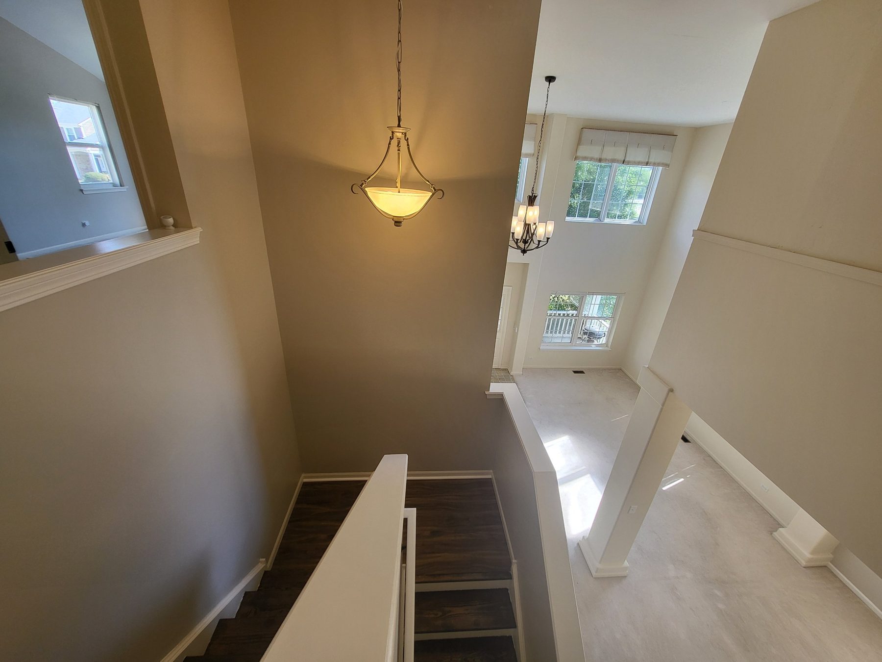 Stair landing with pendant light, looking down over the two-story living room.